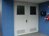 Fahrradraumtür mit Glaseinsatz und Lüftungsschlitzen Fahrradraumtür mit Glaseinsatz und Lüftungsschlitzen