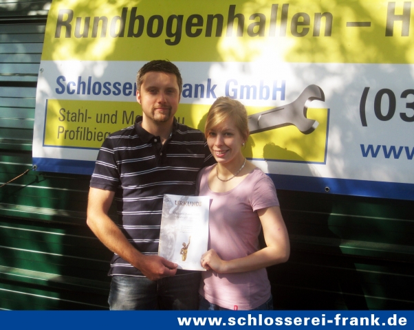 Marcus und Stefanie Frank präsentieren stolz die Urkunde für das Erreichen der Juryliste vor einer i