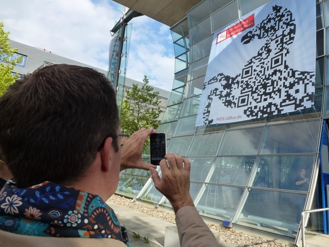 Spaziergänger scannt auf dem Expo-Gelände einen QR-Code im Niedersachsenross Spaziergänger scannt auf dem Expo-Gelände einen QR-Code im Niedersachsenross