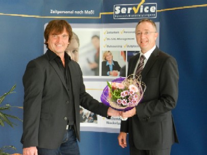 Mit einem Blumenstrauß bedankte sich der IT-Dienstleister für die langjährige Treue und gratulierte 