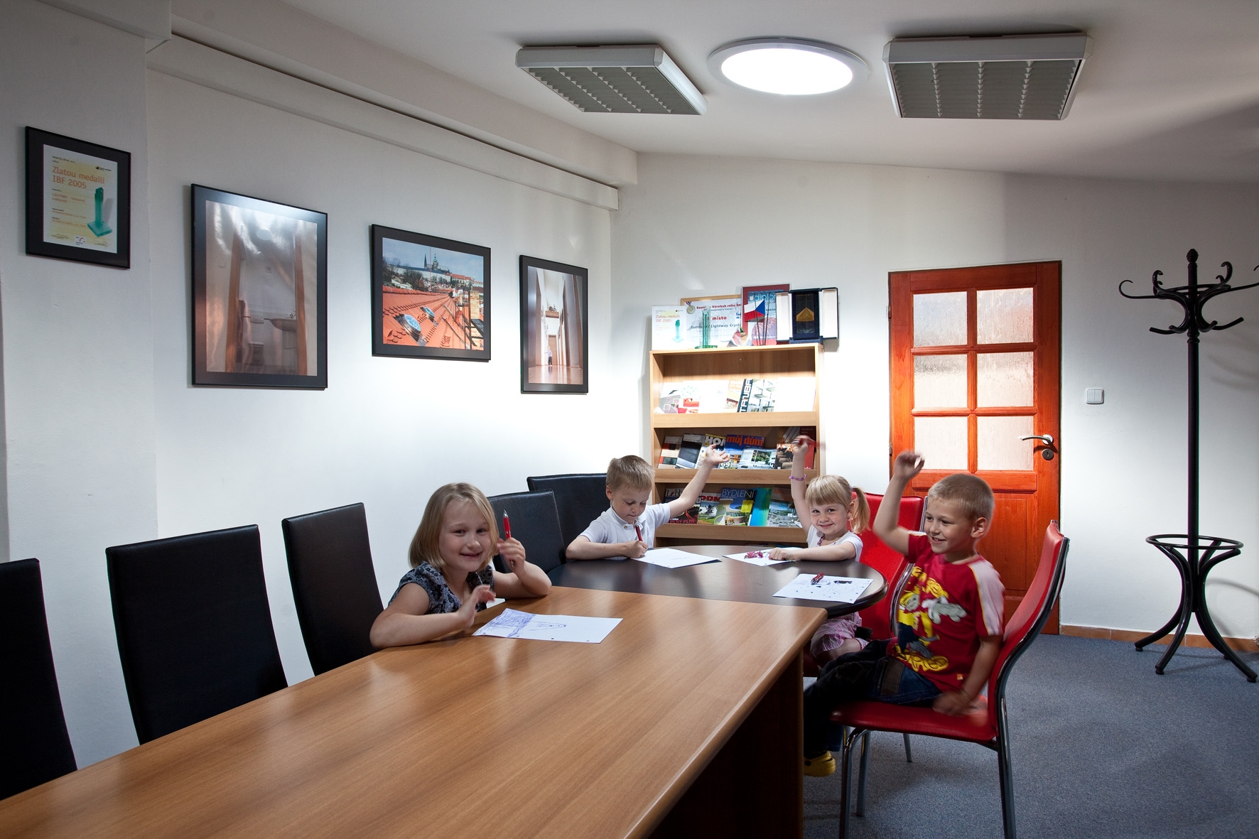 Vier gutgelaunte Kinder in einem taghellen Zimmer