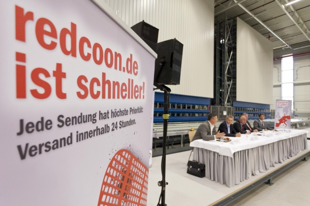 PK im redcoon Logistikzentrum. Im Hintergrund (v. l. n. r.) Reiner Heckel, Pieter Haas, Matthias Mac