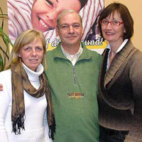 Annemarie Heuer (l.) begrüßt die neuen Franchisepartner John van Benthem und Walburga Frewer.