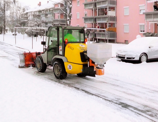 HKL Radlader mit Schneeschild und Streuer sorgt für sichere Straßen im bayerischen Kaufbeuren.