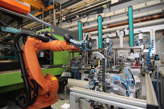 Fertigungsanlage für ein Elektronikgehäuse mit umspritzten Steckerkontakten