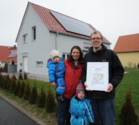 Familie Modler mit Zertifizierungs-Urkunde vor ihrem Plusenergiehaus. Familie Modler mit Zertifizierungs-Urkunde vor ihrem Plusenergiehaus.
