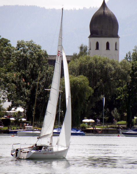 Segeln auf dem Chiemsee mit Blick auf den Campanile von Kloster Frauenwörth. Foto: Hötzelsperger