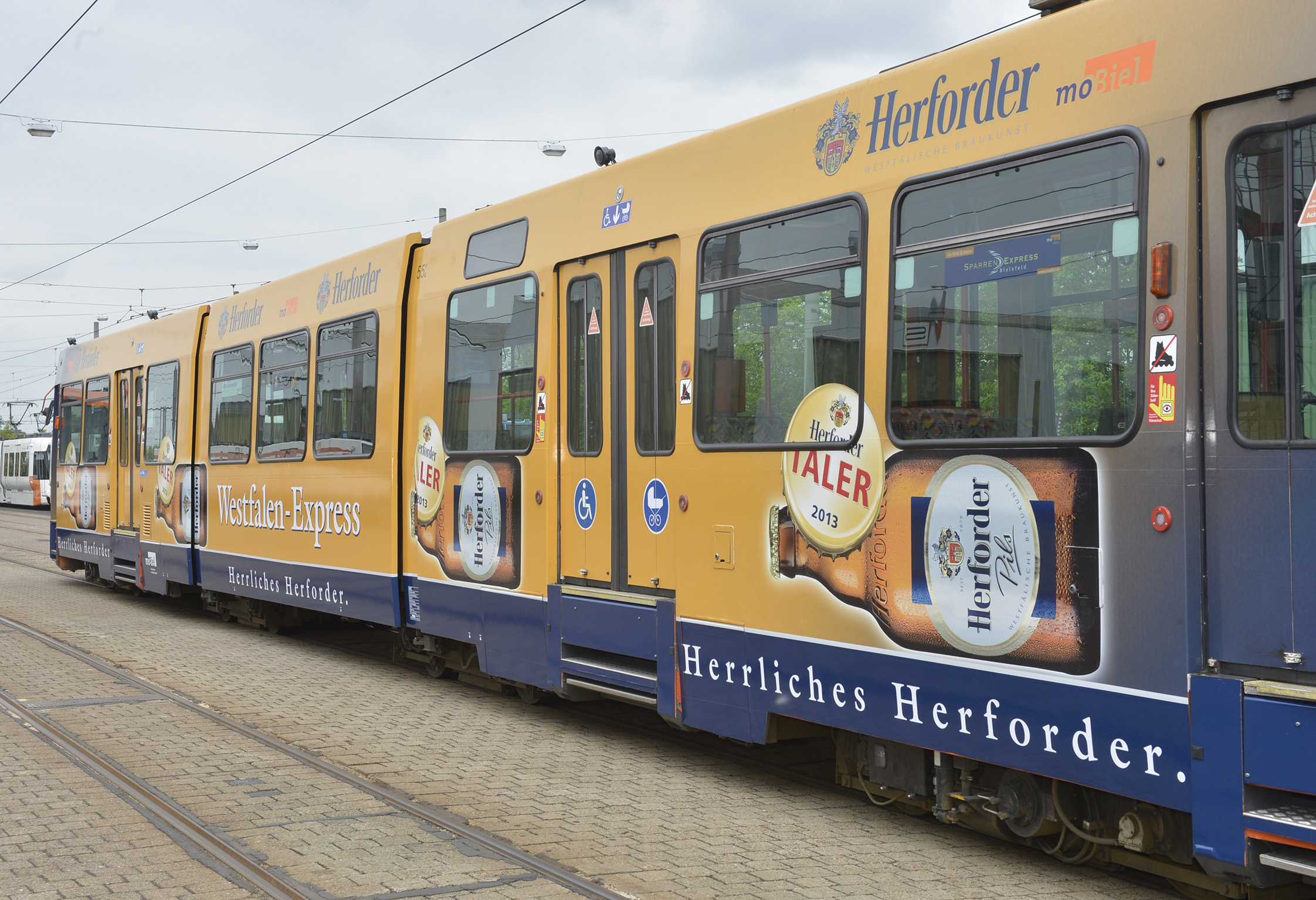 Der 26 Meter lange StadtBahnzug der Verkehrsbetriebe moBiel in den Farben von Herforder Pils.