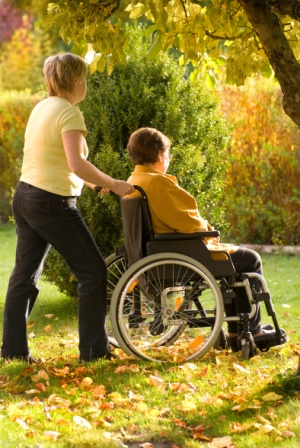 Eine Pflegekraft hilft auch bei einem kleinen Spaziergang Eine Pflegekraft hilft auch bei einem kleinen Spaziergang