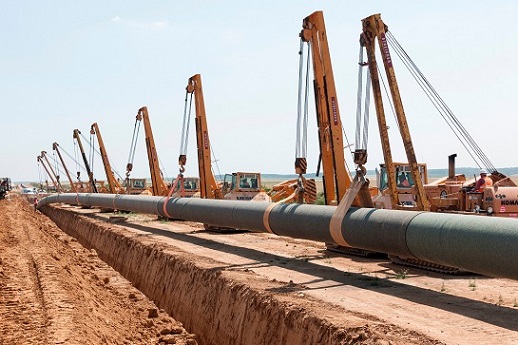 Neun Seitenbaumraupen senken die Pipeline in den Rohrgraben ab.