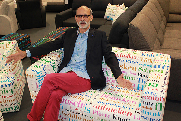 Wolfgang Döll präsentiert das 2er Sofa TUBA mit dem Stoff WESTFALIA auf dem Messestand
